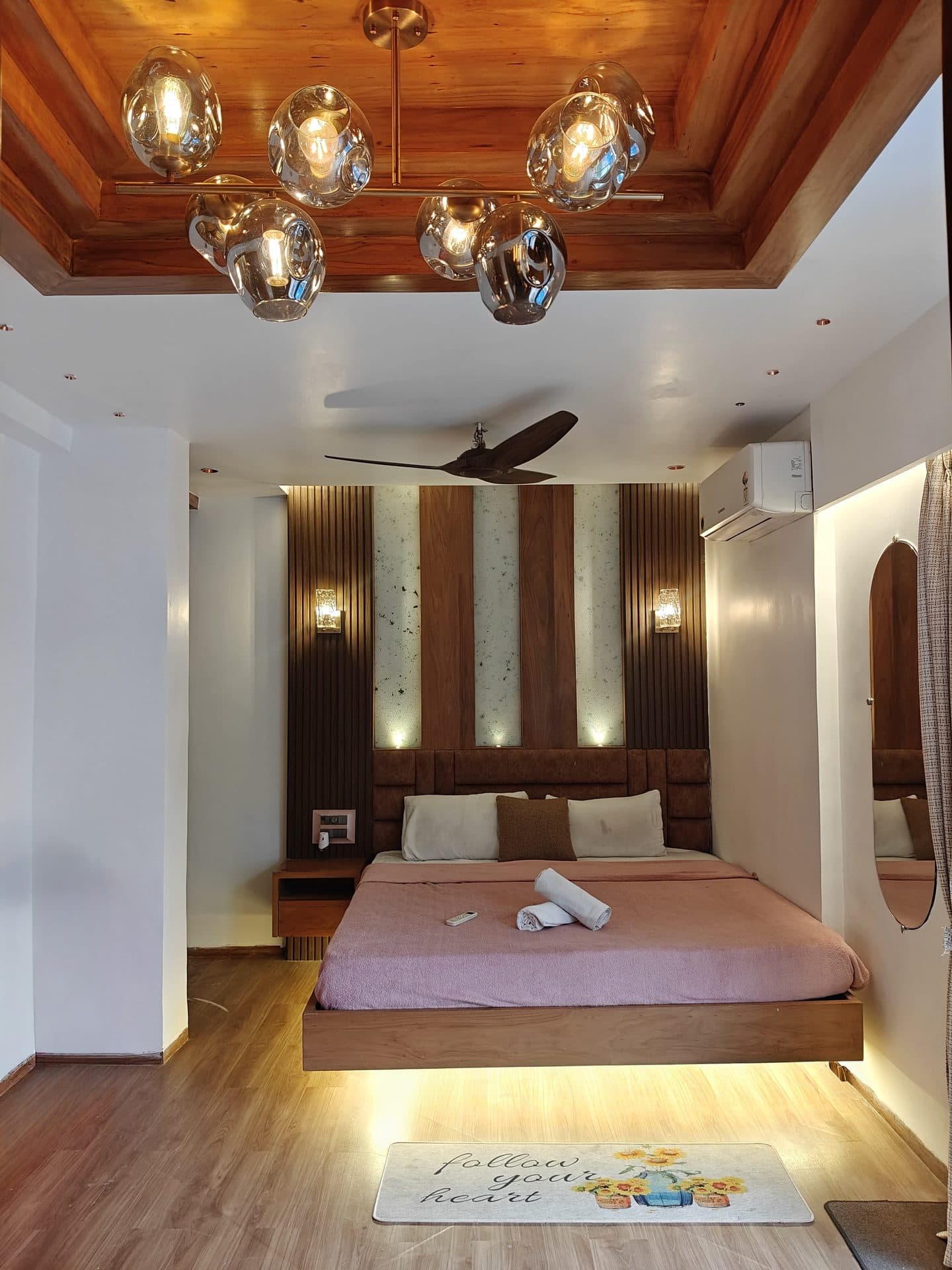Bedroom with pink bed and statement chandelier