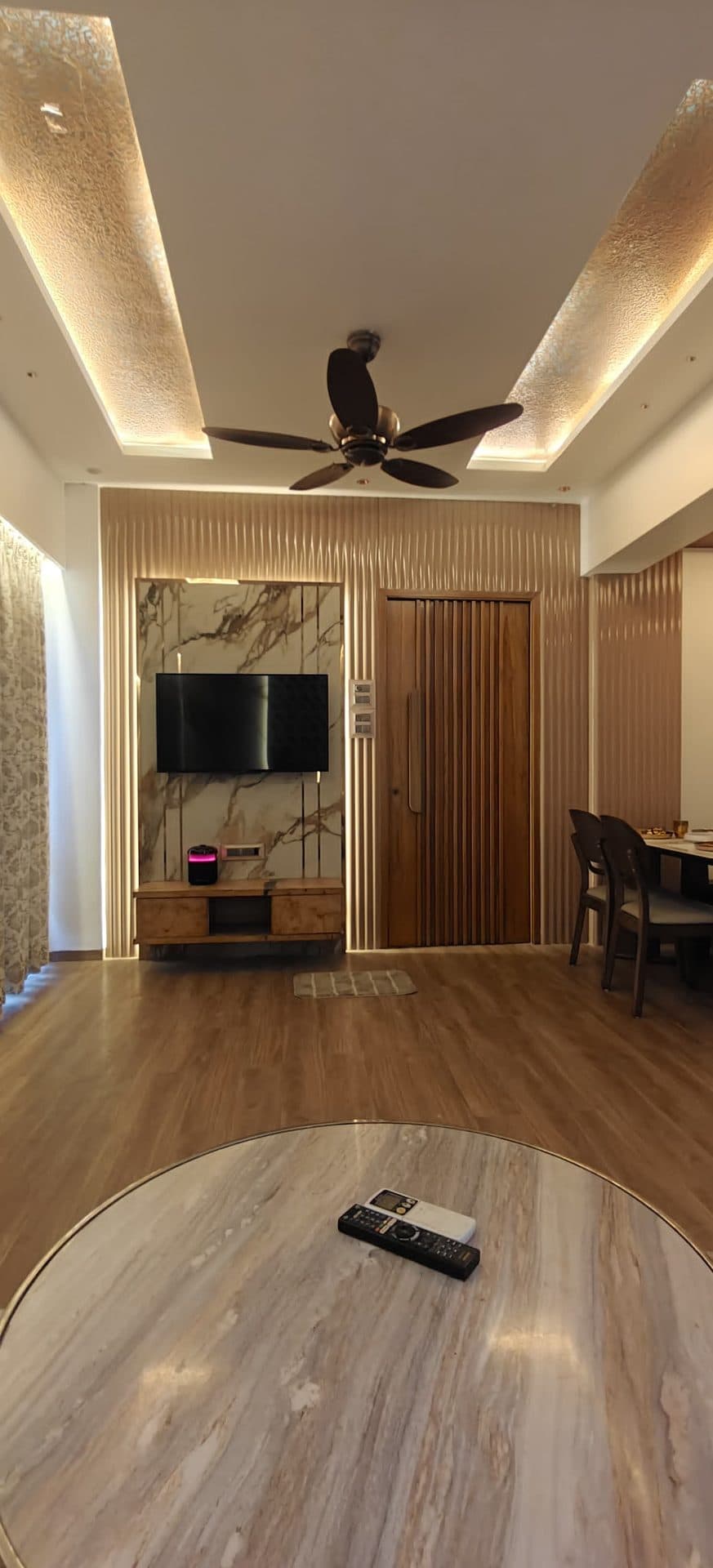 Living area with TV console and marble wall