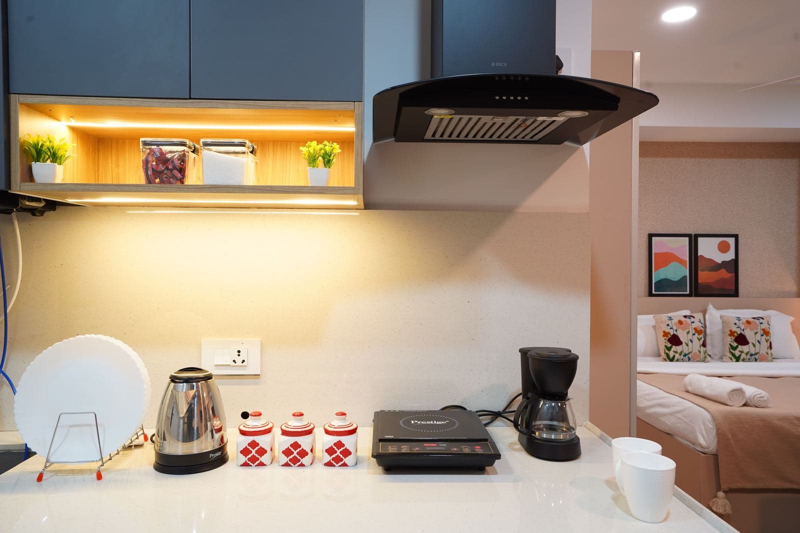 Kitchen counter with an illuminated display shelf, electric kettle, and coffee maker
