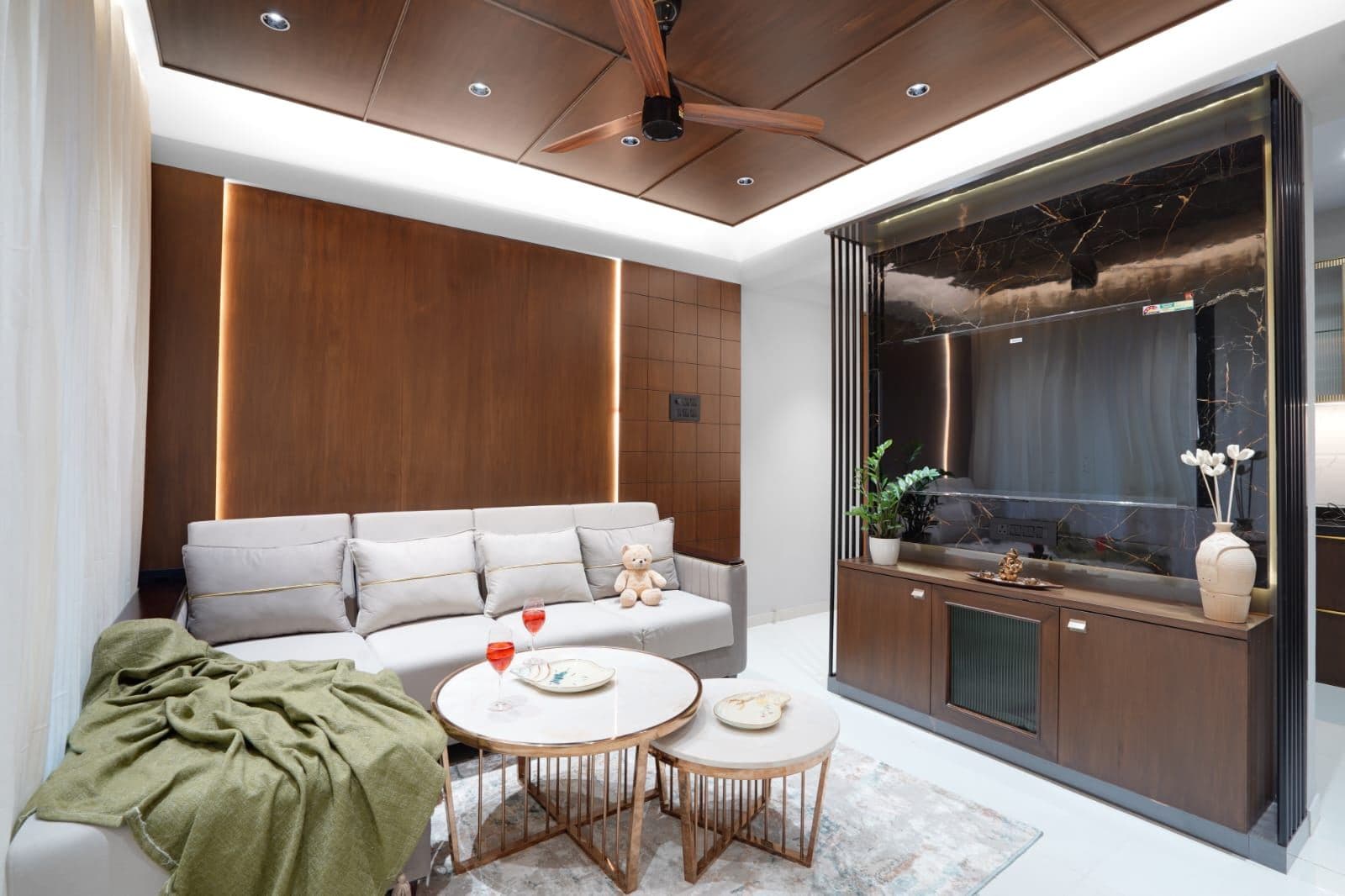 Living room sofa facing a dark marble media wall with recessed television