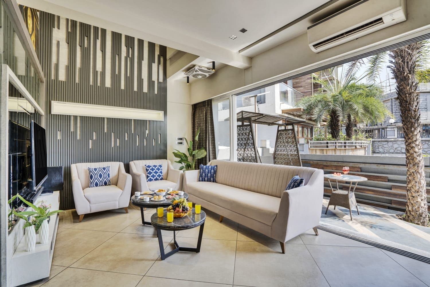 Living room opening onto palm-shaded outdoor terrace