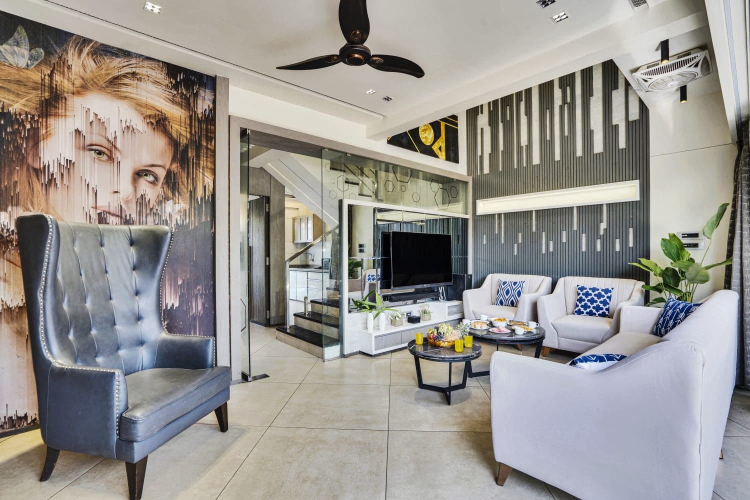 Living room with tufted wingback chair and portrait wall art