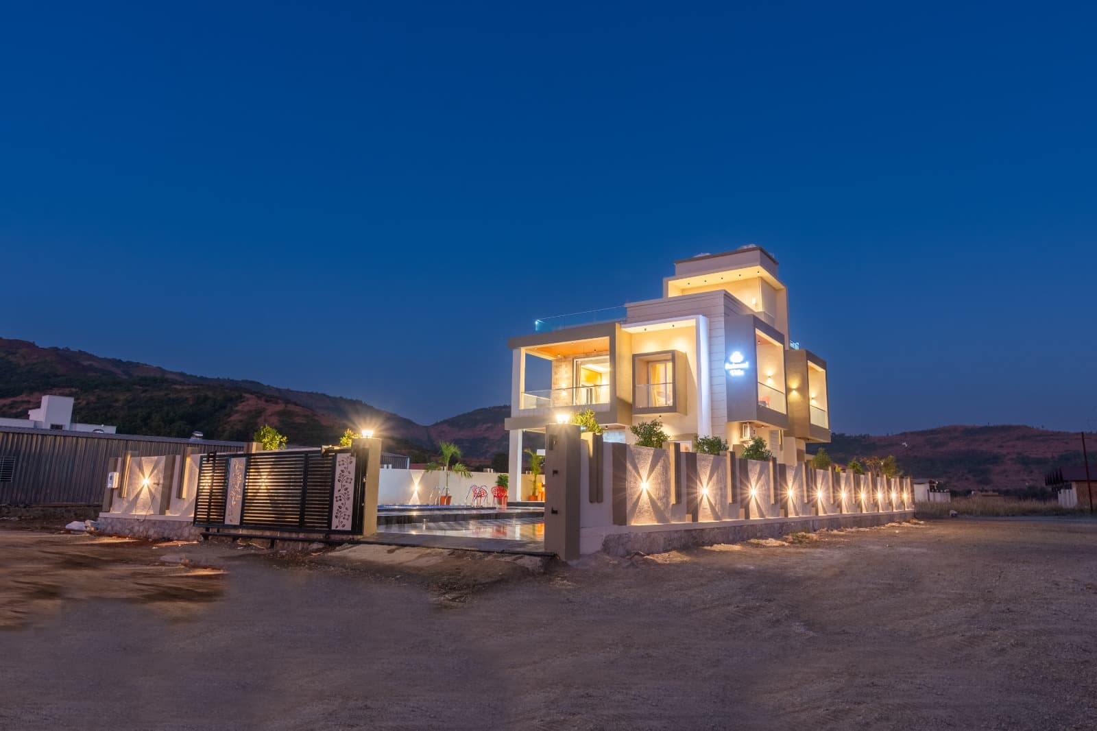 Villa front elevation and gated entrance at dusk