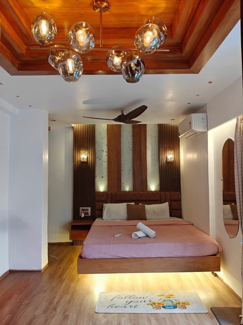 Bedroom with pink bed and pendant lighting