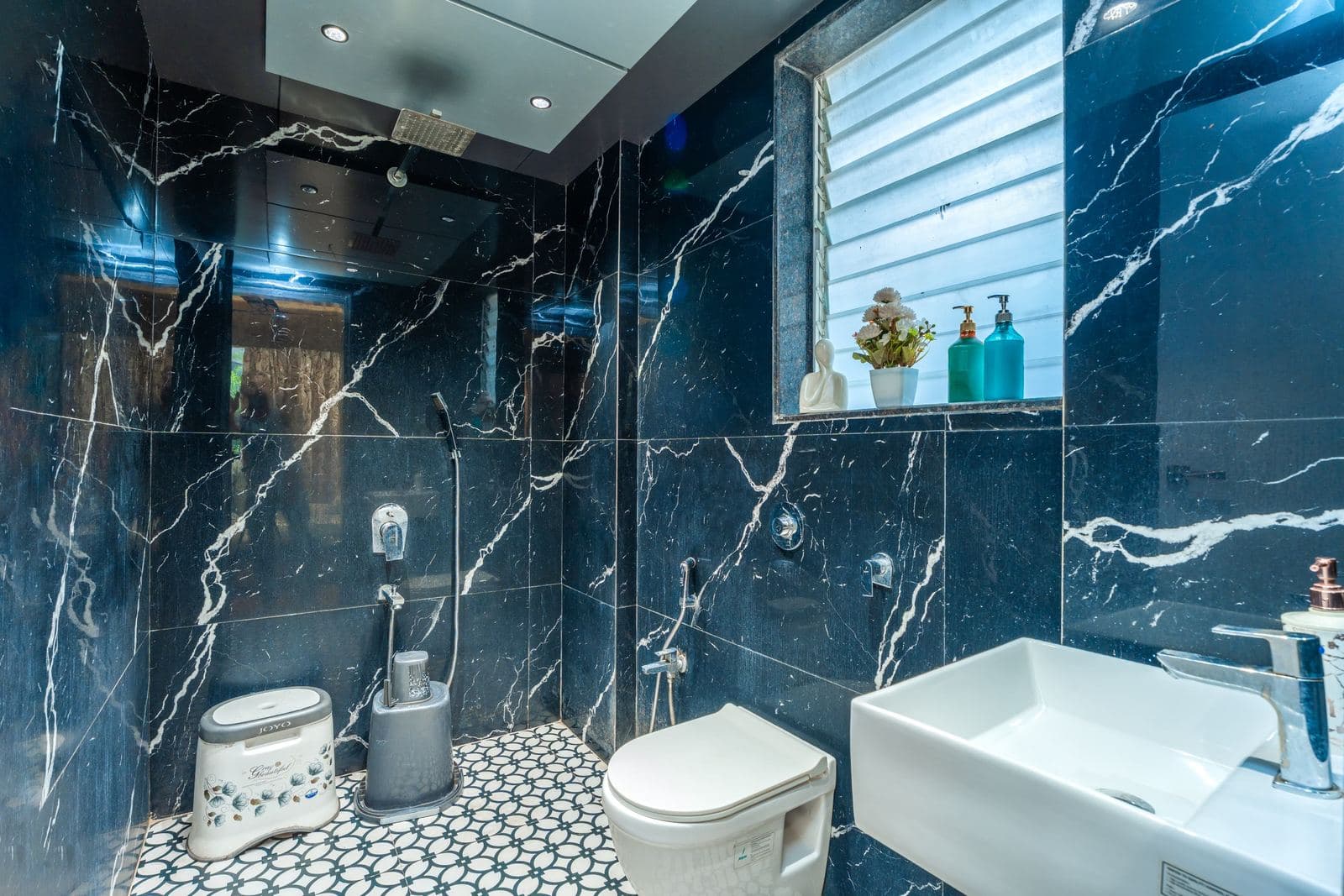 Dark marble bathroom with toilet and sink