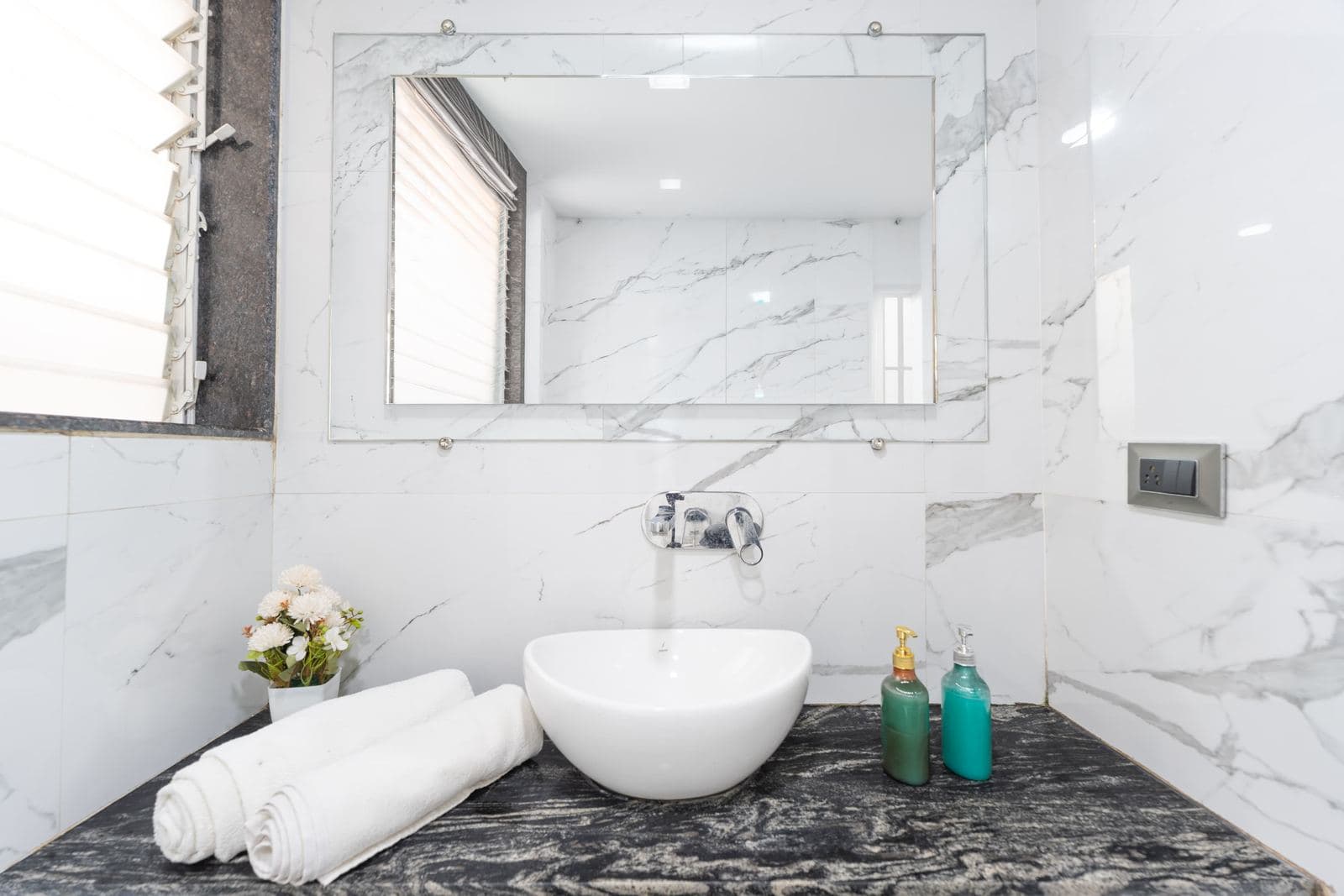 Marble bathroom vanity with vessel sink and folded towels