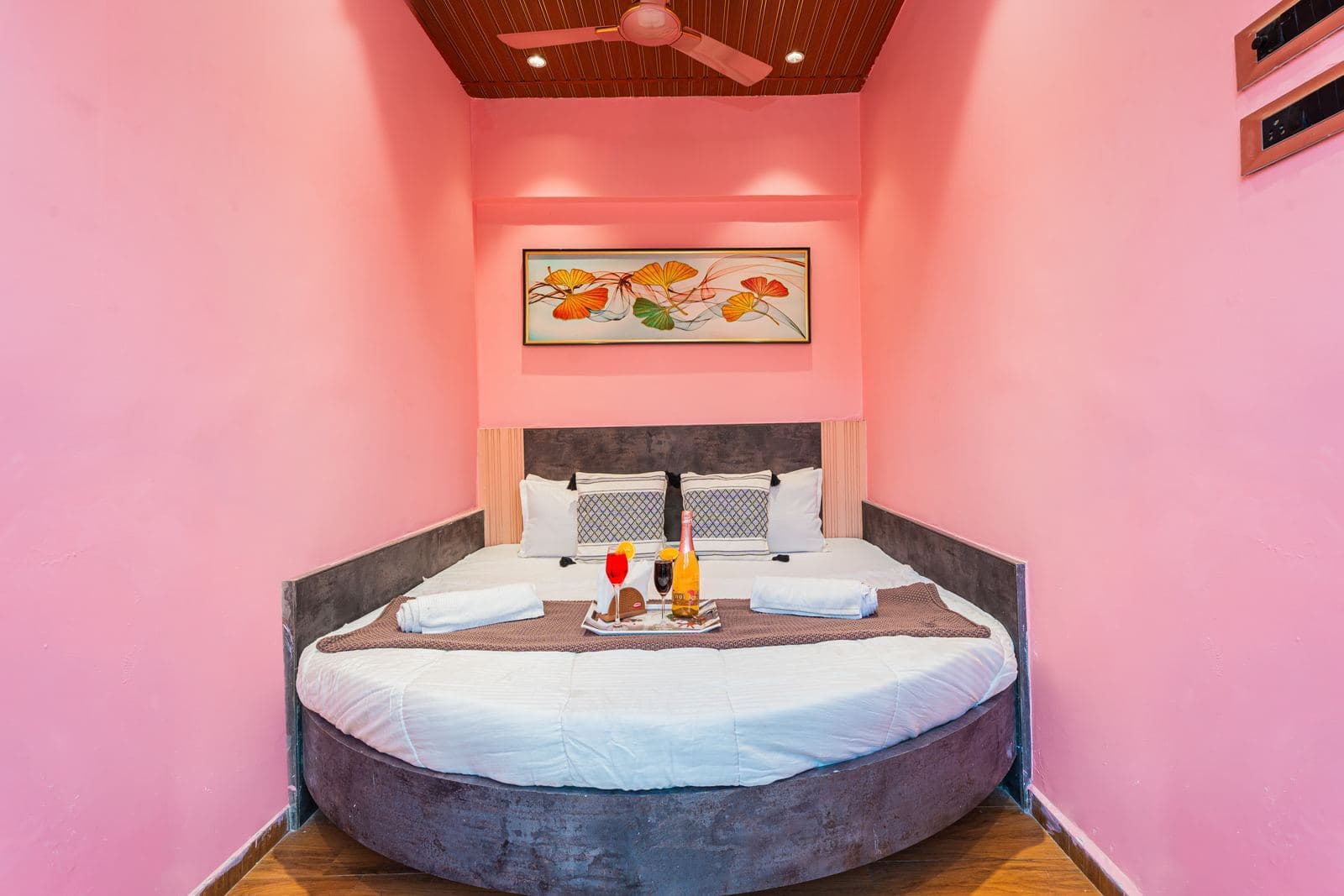 Bedroom with pink accent wall and round bed