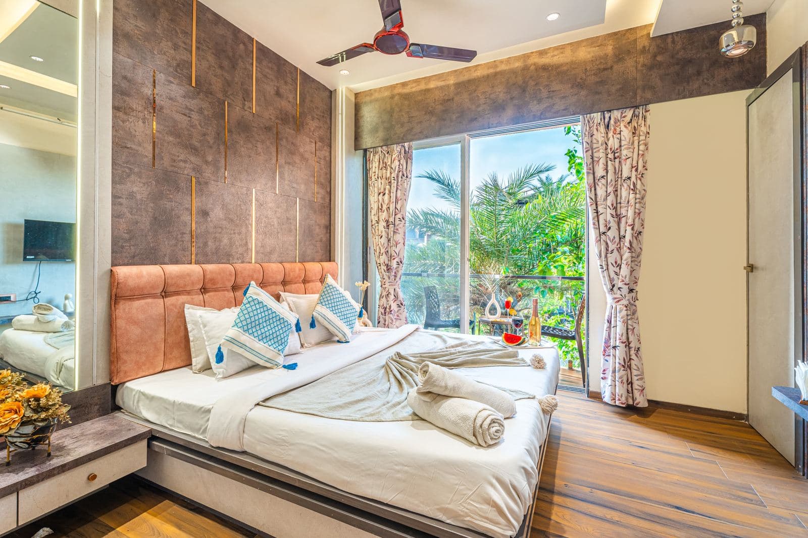 Bedroom with textured accent wall and pool-view balcony doors