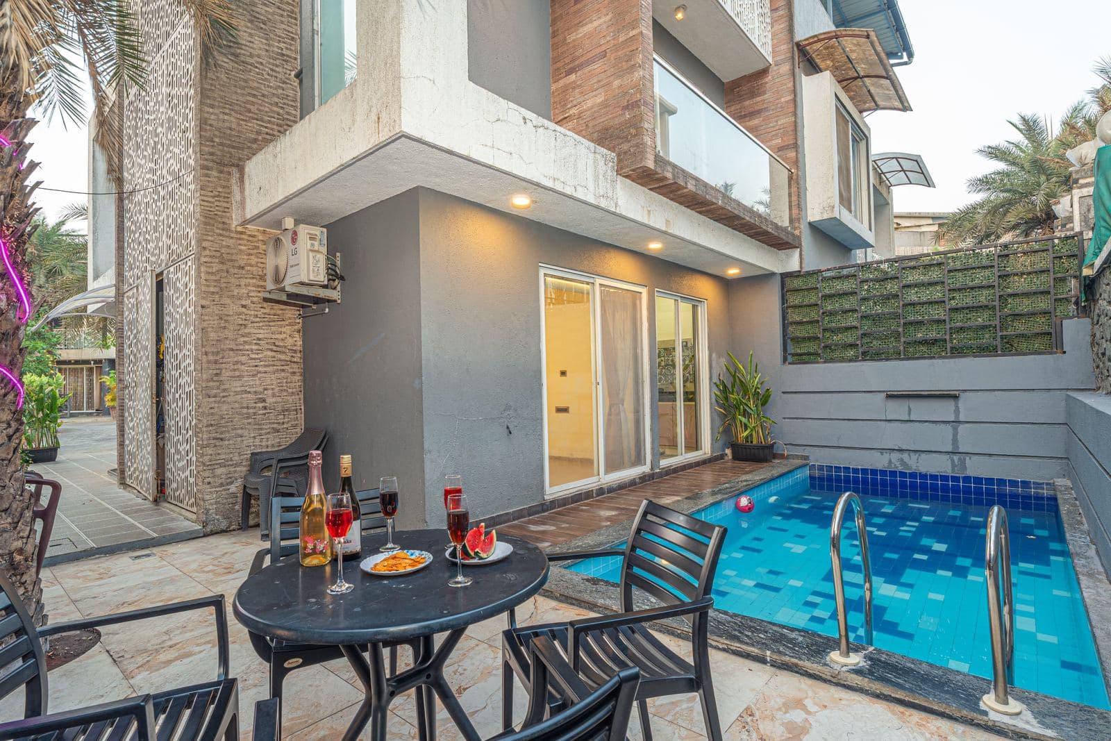 Poolside dining table set against the villa facade
