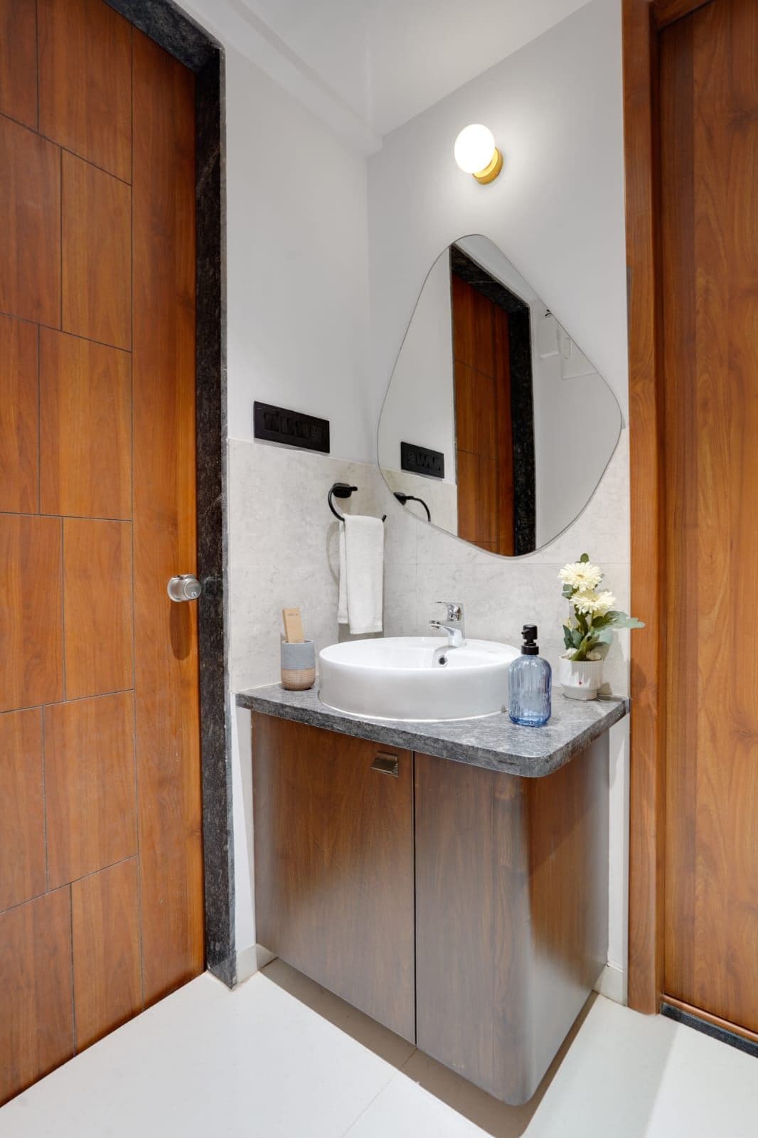 Vanity nook with round countertop basin and curved frameless mirror