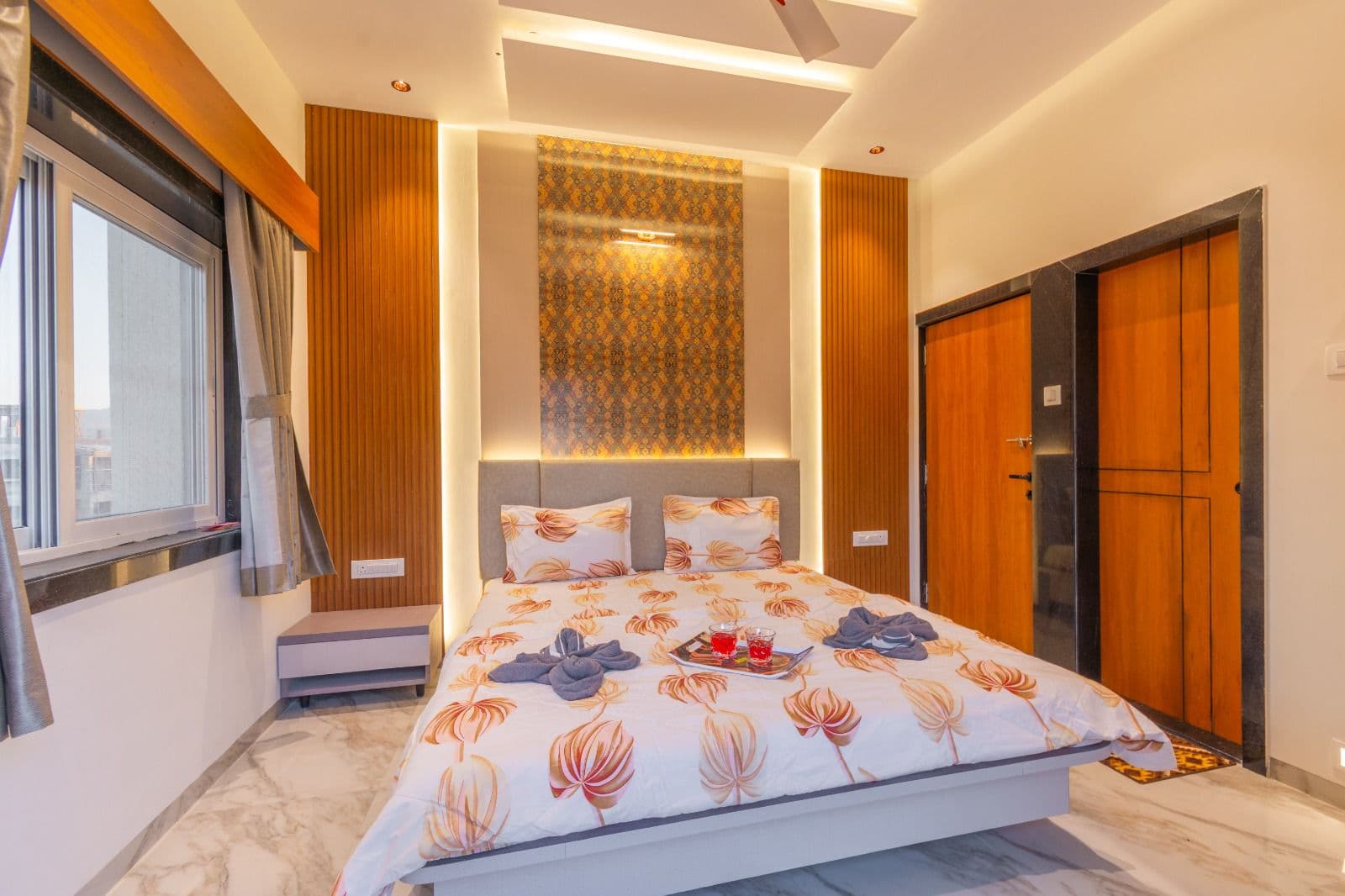 Bedroom with floral bedding and wood-panelled wardrobe doors