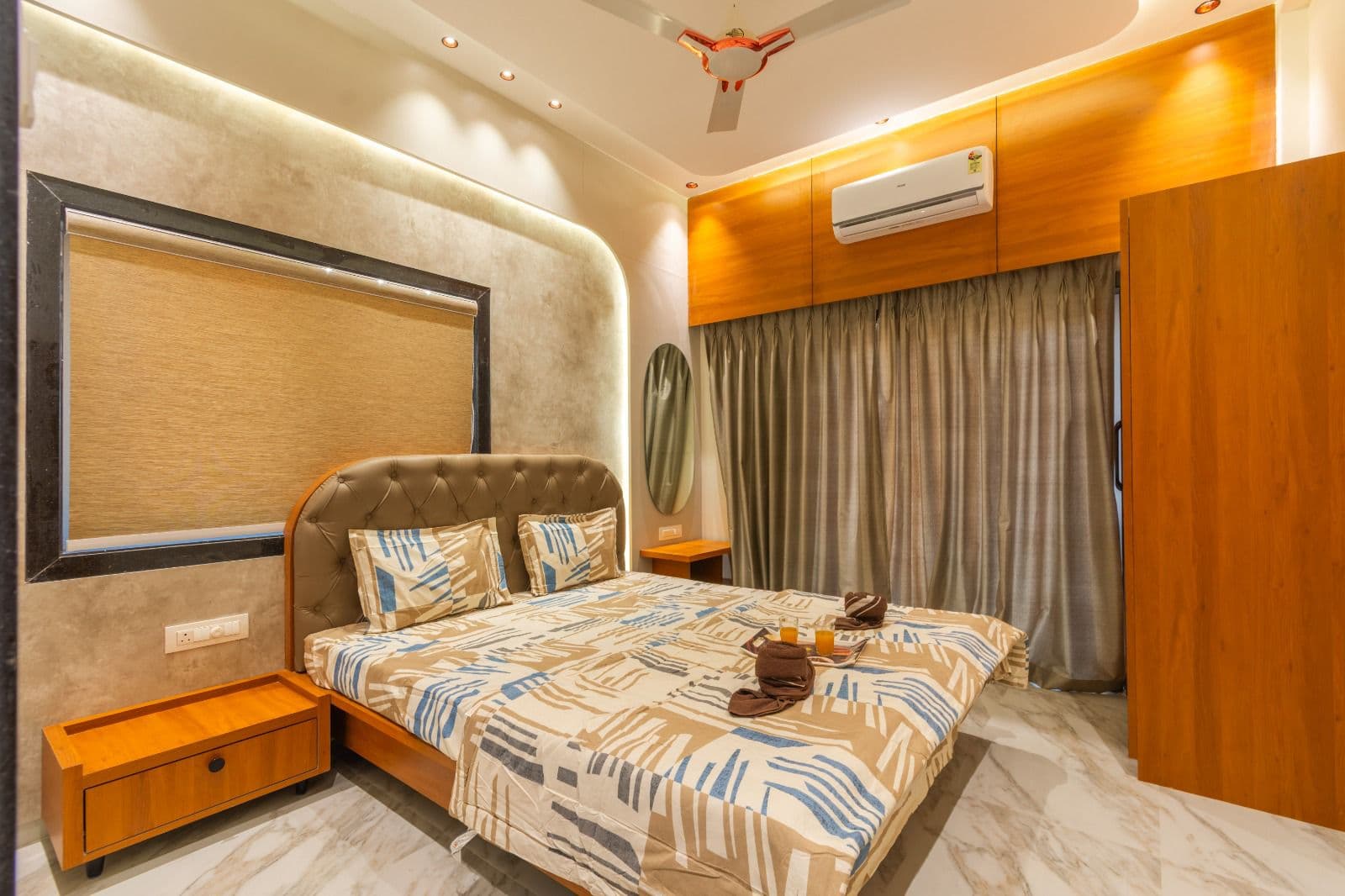 Bedroom with diamond-tufted leather headboard and striped bedding
