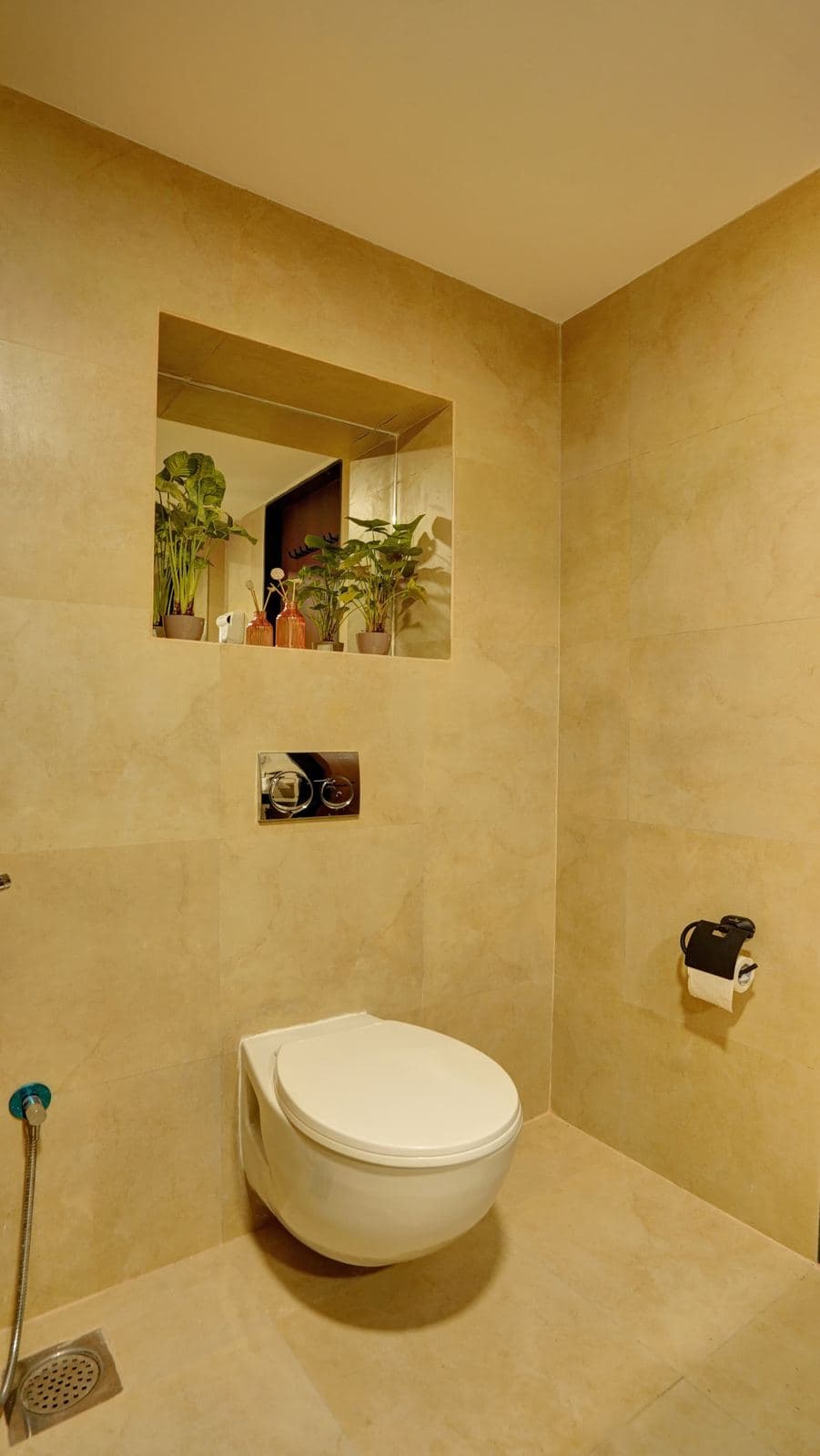 Toilet nook with tiled wall niche and potted plants