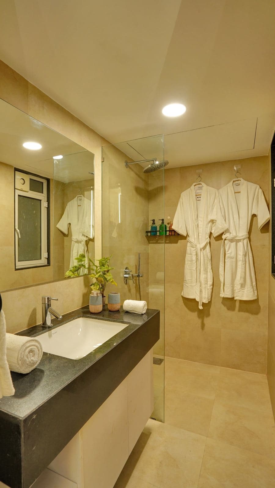 Shower area with hanging bathrobes and rain showerhead