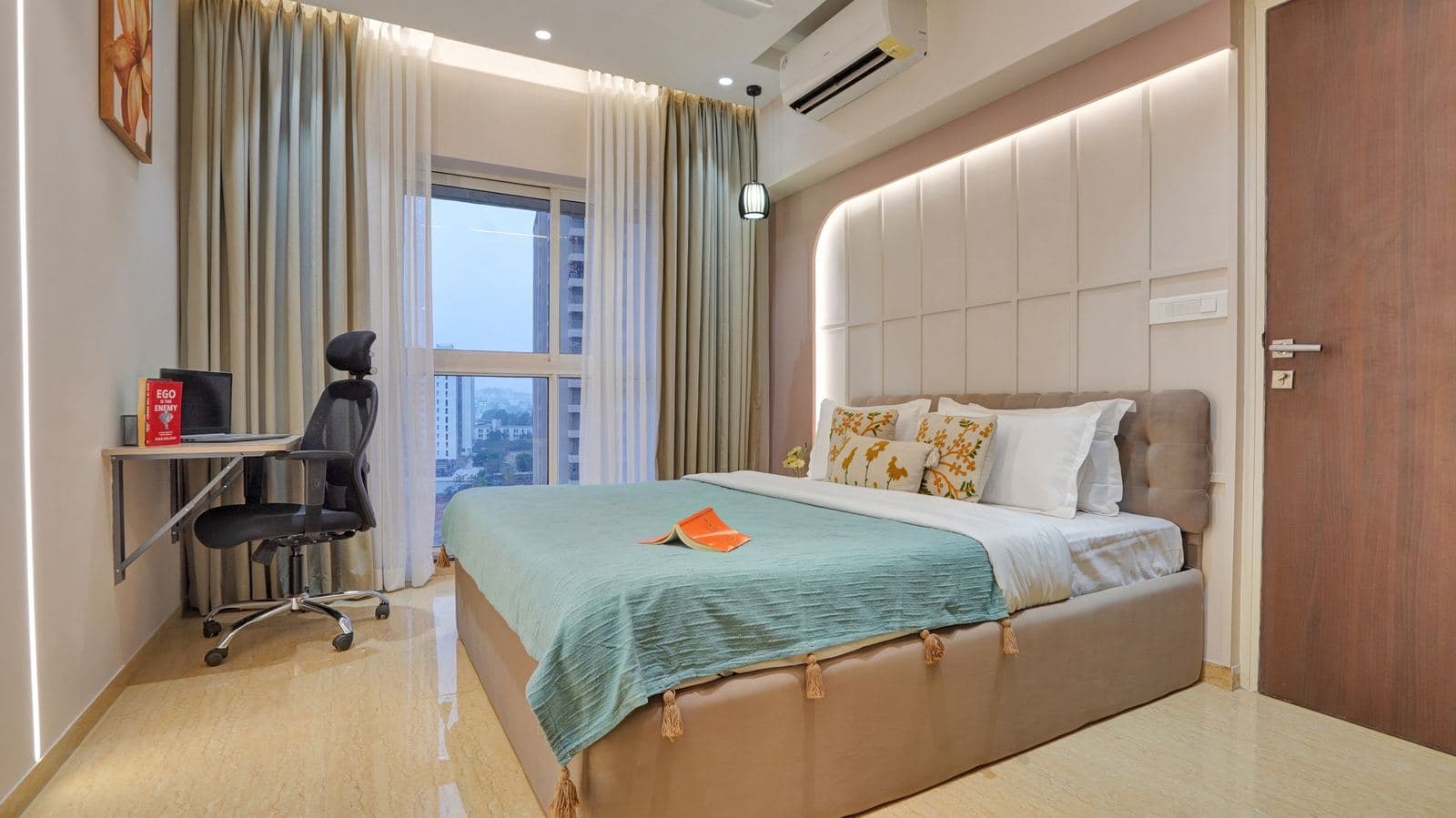 Bedroom workspace beside a curtained city-view window